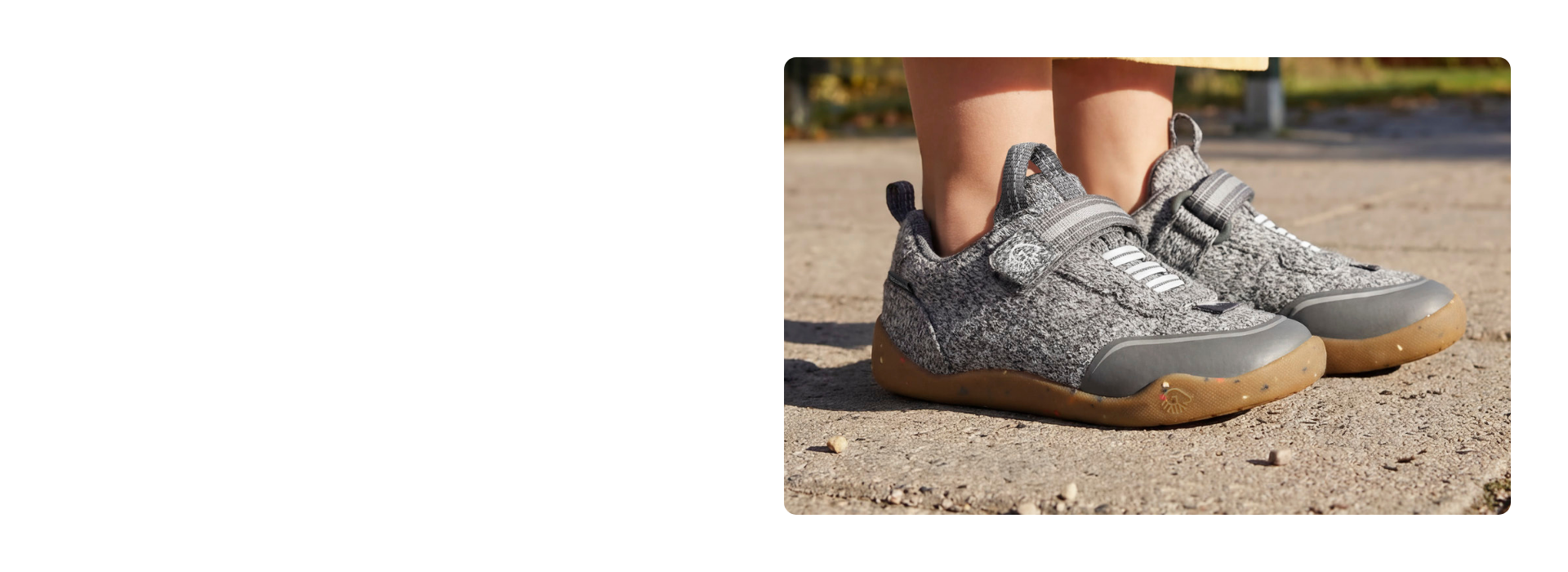 Gros plan sur des baskets pour enfants Giesswein grises, avec une tige en laine mérinos, une fermeture velcro et une semelle couleur miel, sur un chemin de sable.